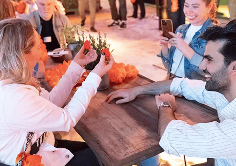 Mitarbeiter interagieren bei einem Event mit einem Zauberer. Elias Noro